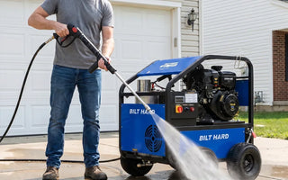 Hot water power washer cleaning a concrete driveway