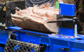 Hydraulic log splitter cutting a tough hardwood log