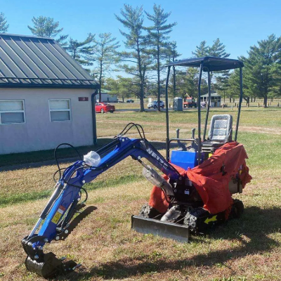 BILT HARD mini excavator working on grassy terrain