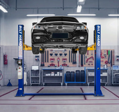 Two-post car lift raising a sedan in garage