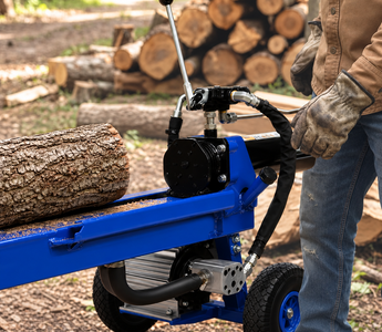 Worker preparing maple firewood with a hydraulic log splitter