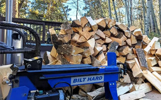 BILT HARD Electric Log Splitter beside split firewood